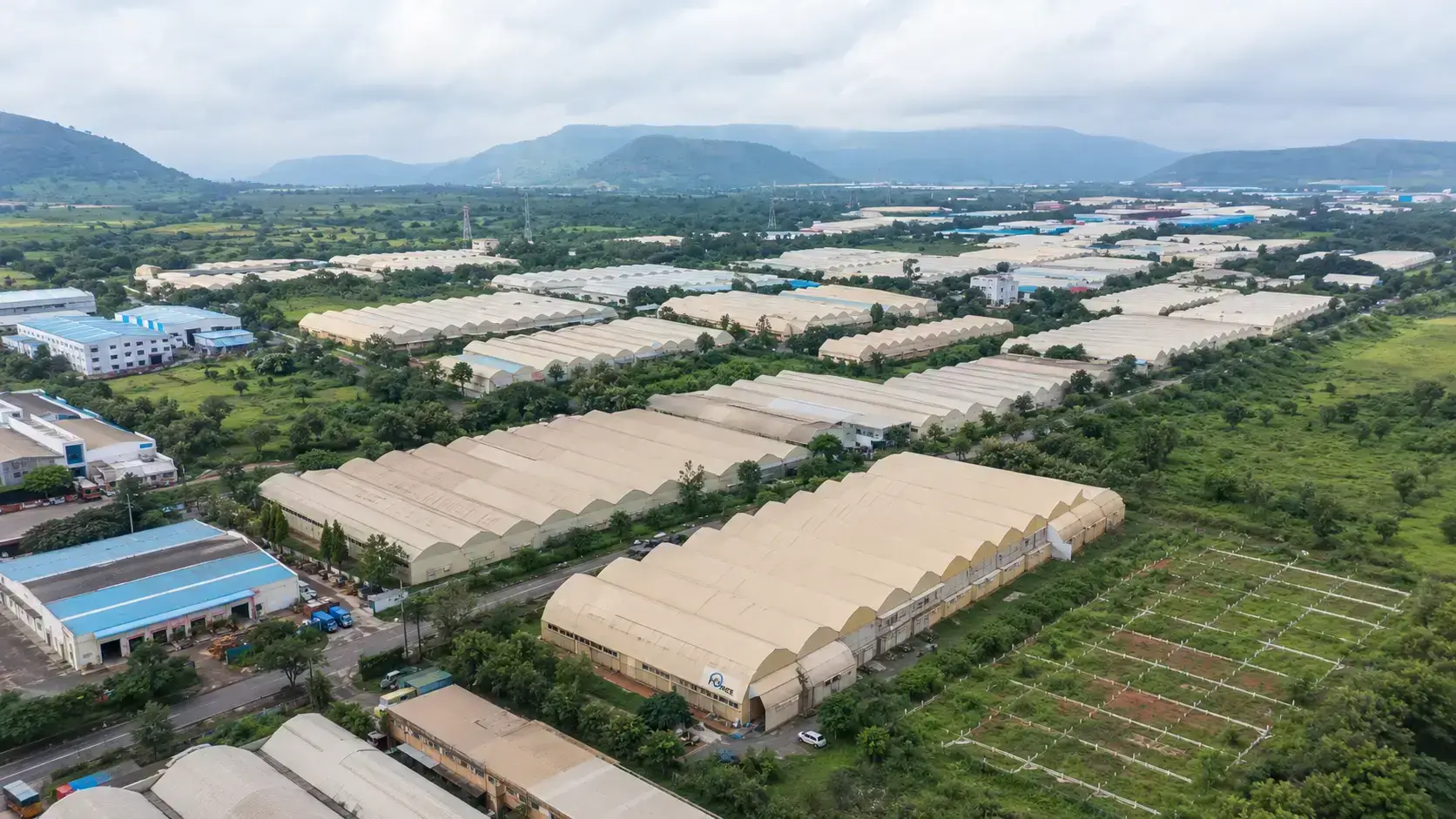 Modern manufacturing facilities and paved access roads inside the Talegaon MIDC industrial area, part of the wider Chakan-Talegaon corridor.